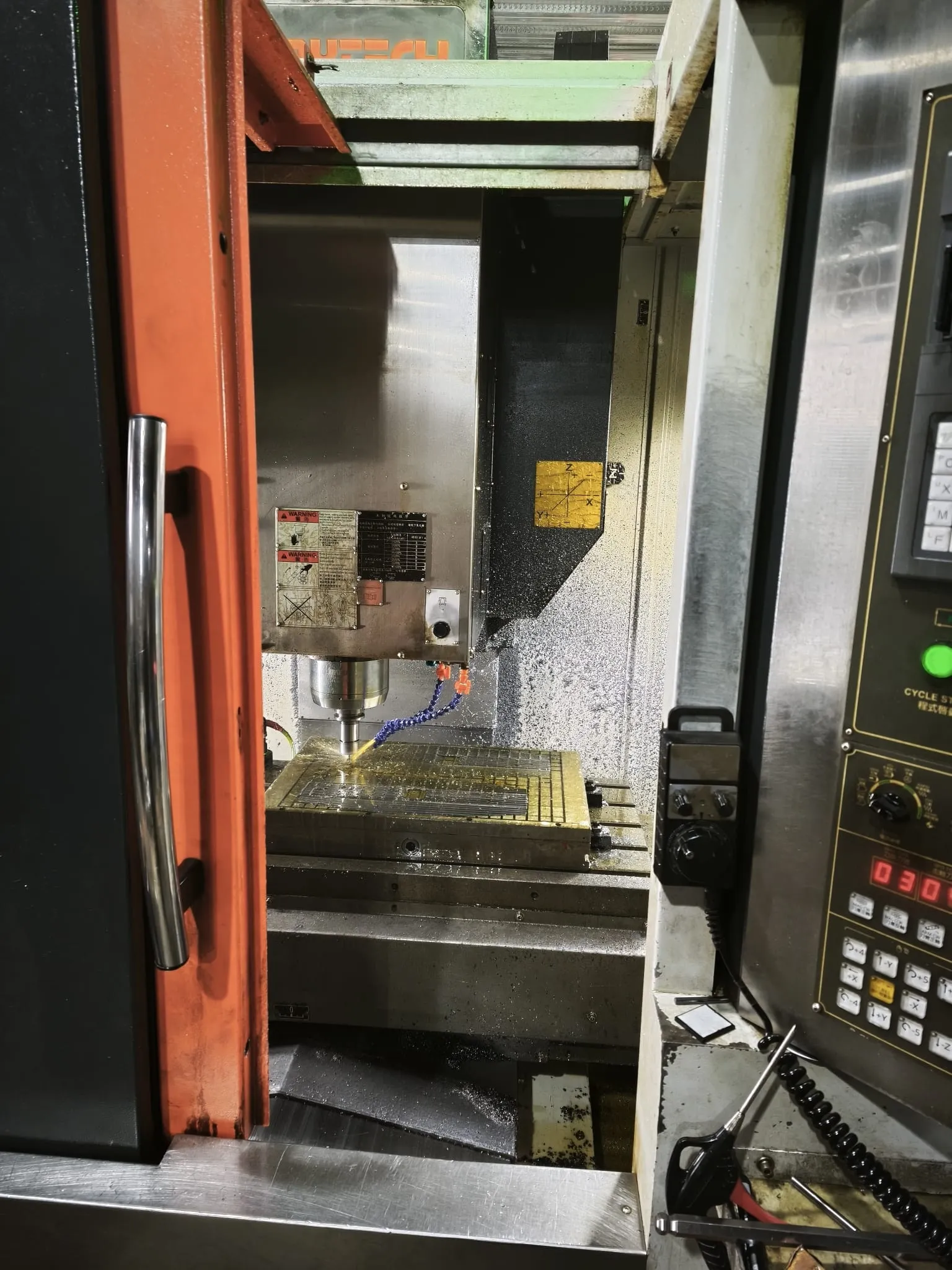 Tool steel plate being milled inside a CNC machine