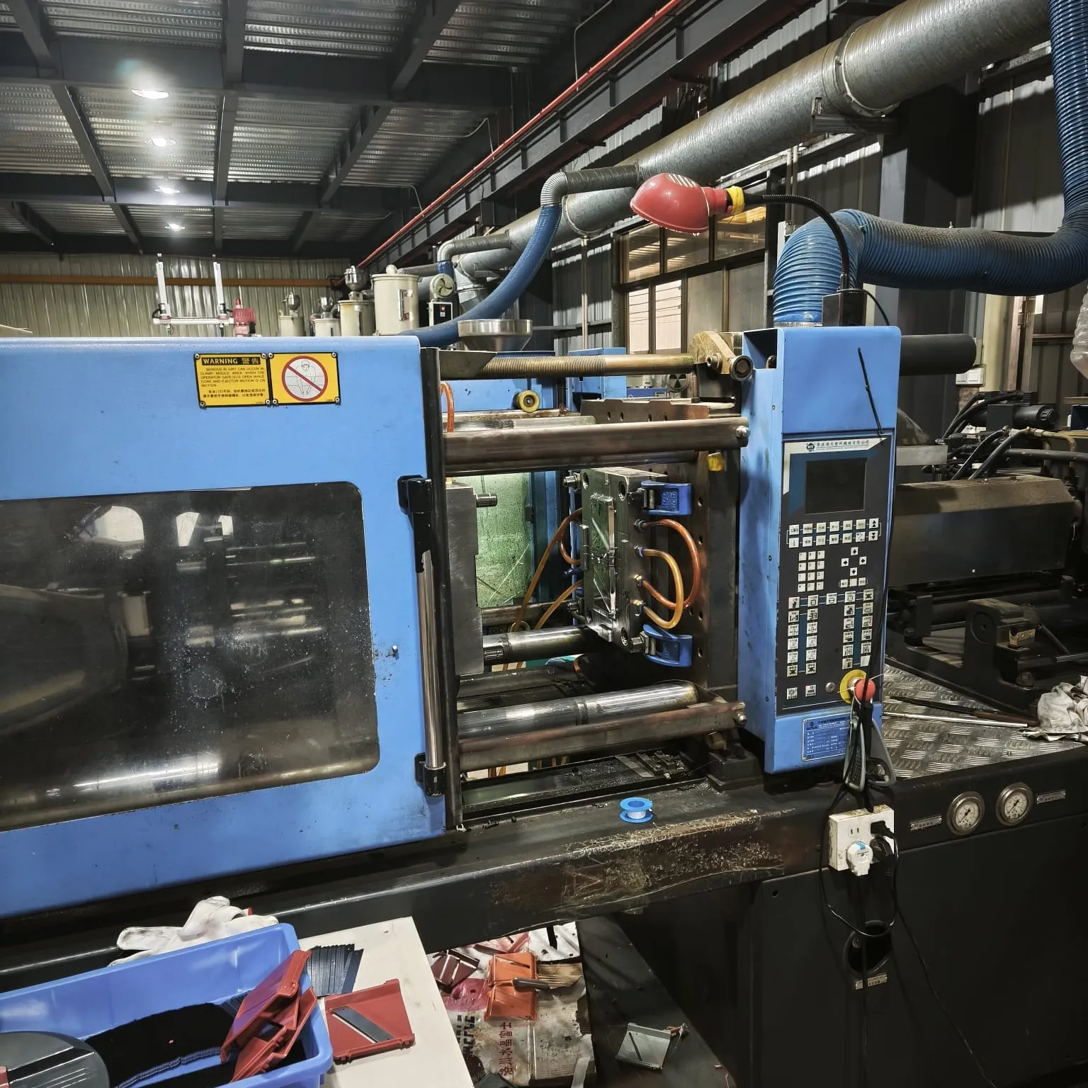 Injection molding machine with feed hoses and a material dryer in the KOVA factory