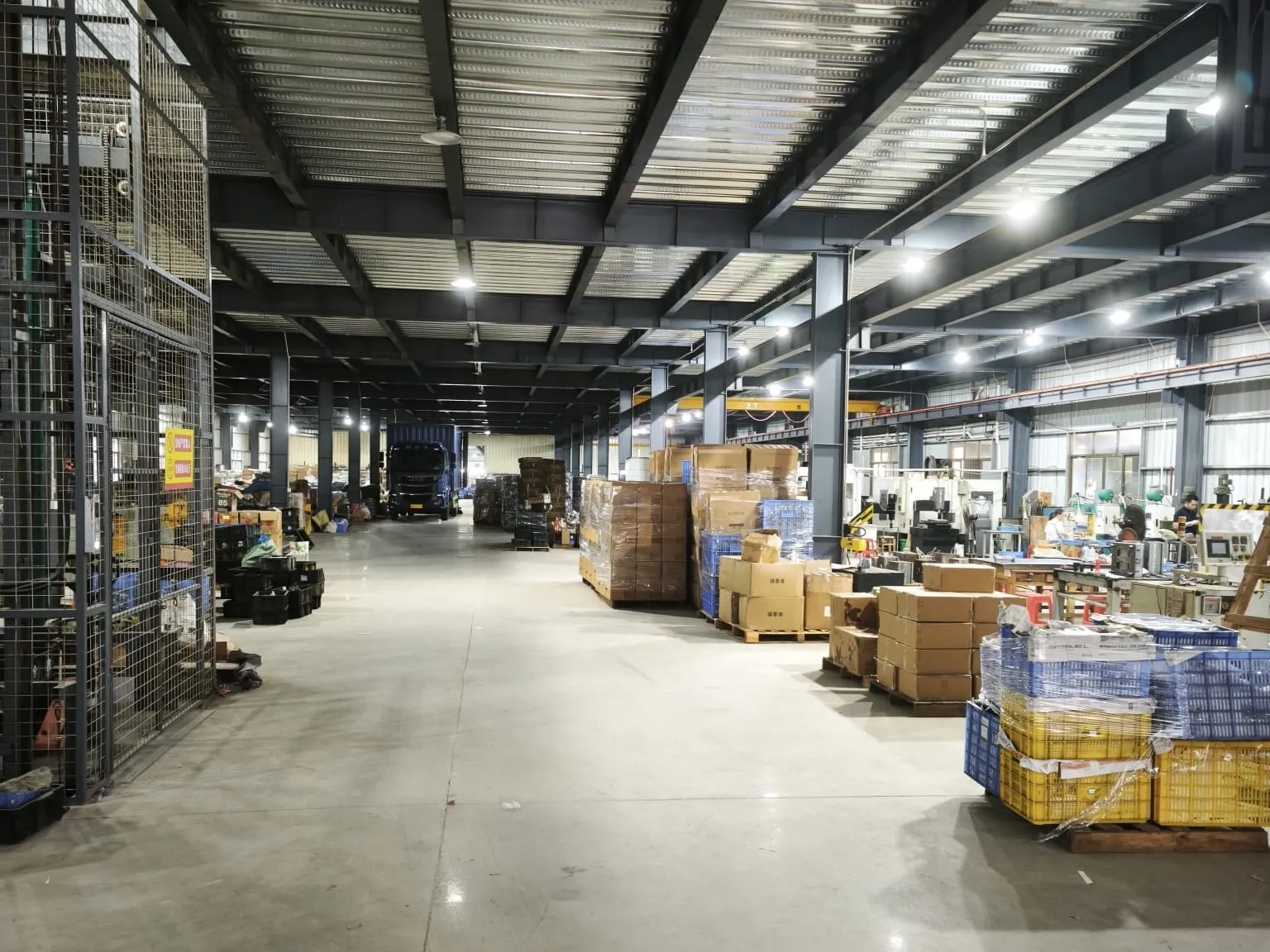 Main factory hall with packed cartons staged along the aisle