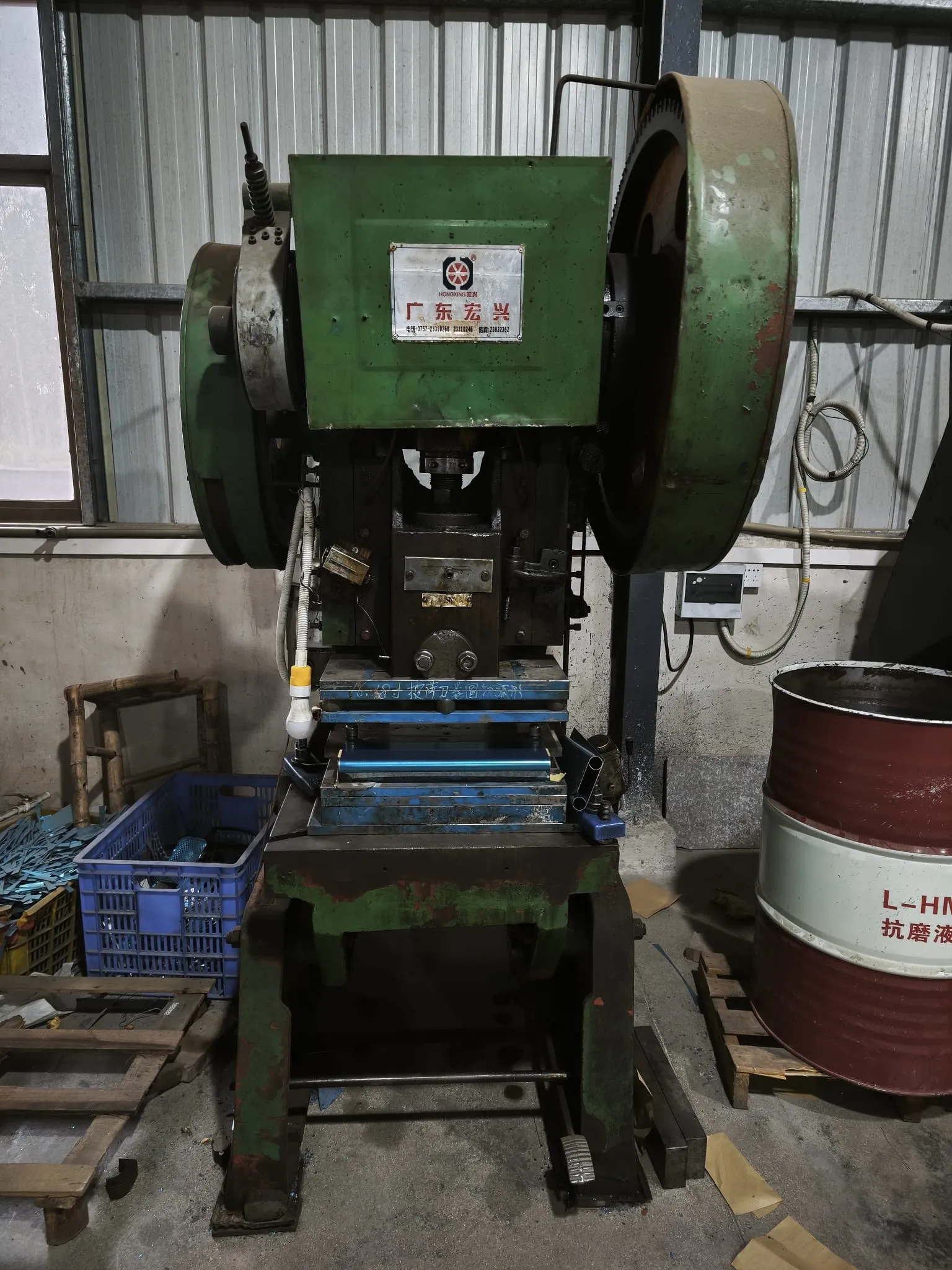 Mechanical press with its tooling and a crate of stamped parts
