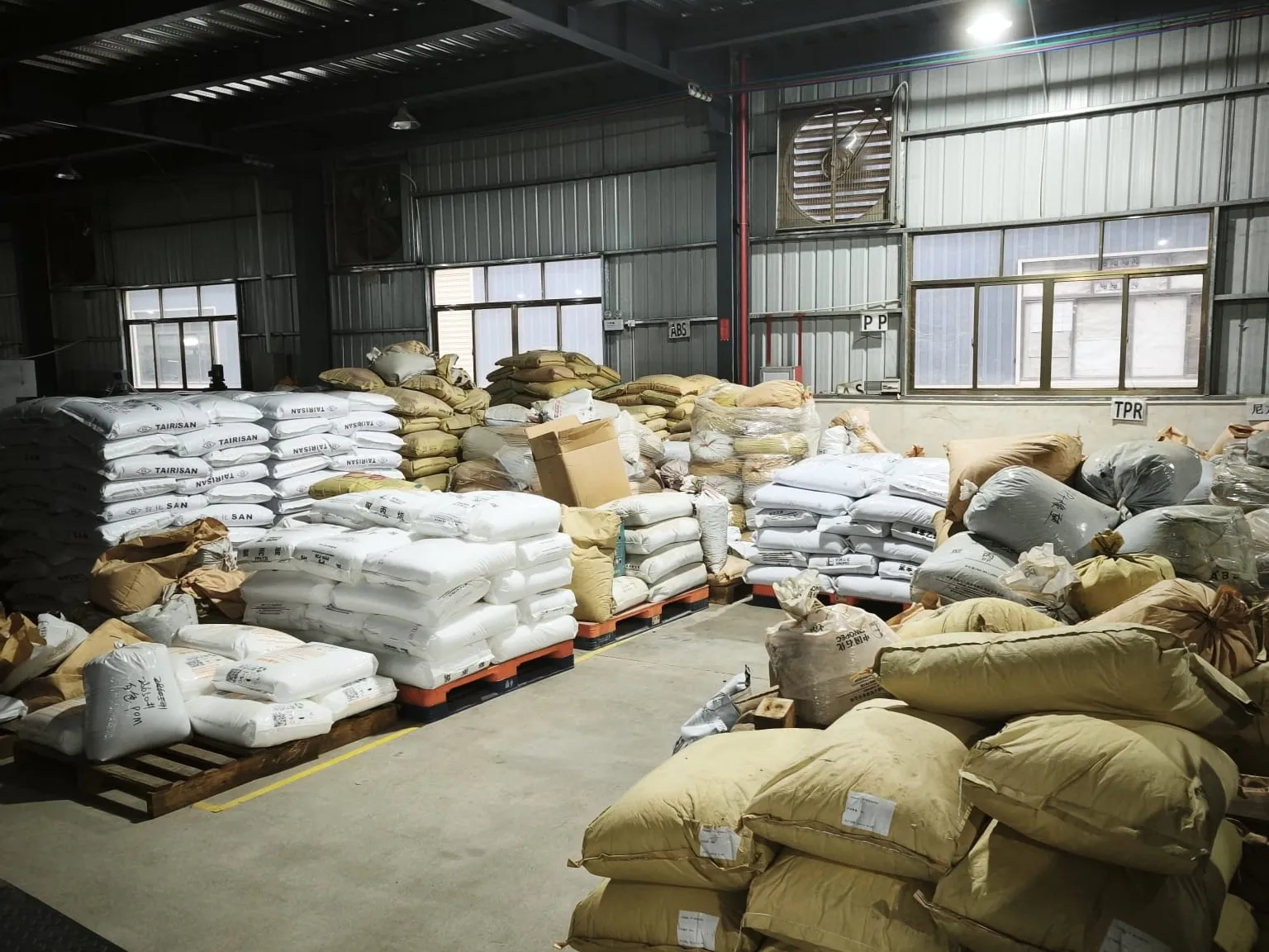 Sacks and bulk bags of plastic granules stored on pallets in the materials bay