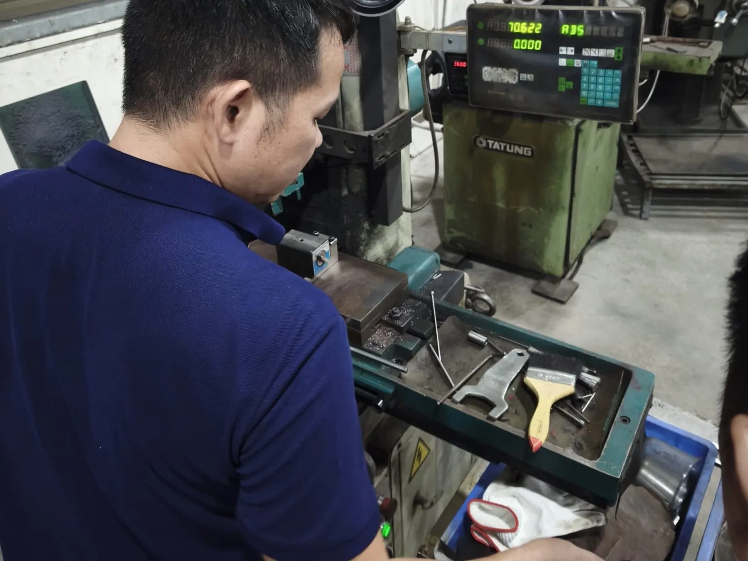 Toolmaker setting up a part on a surface grinder